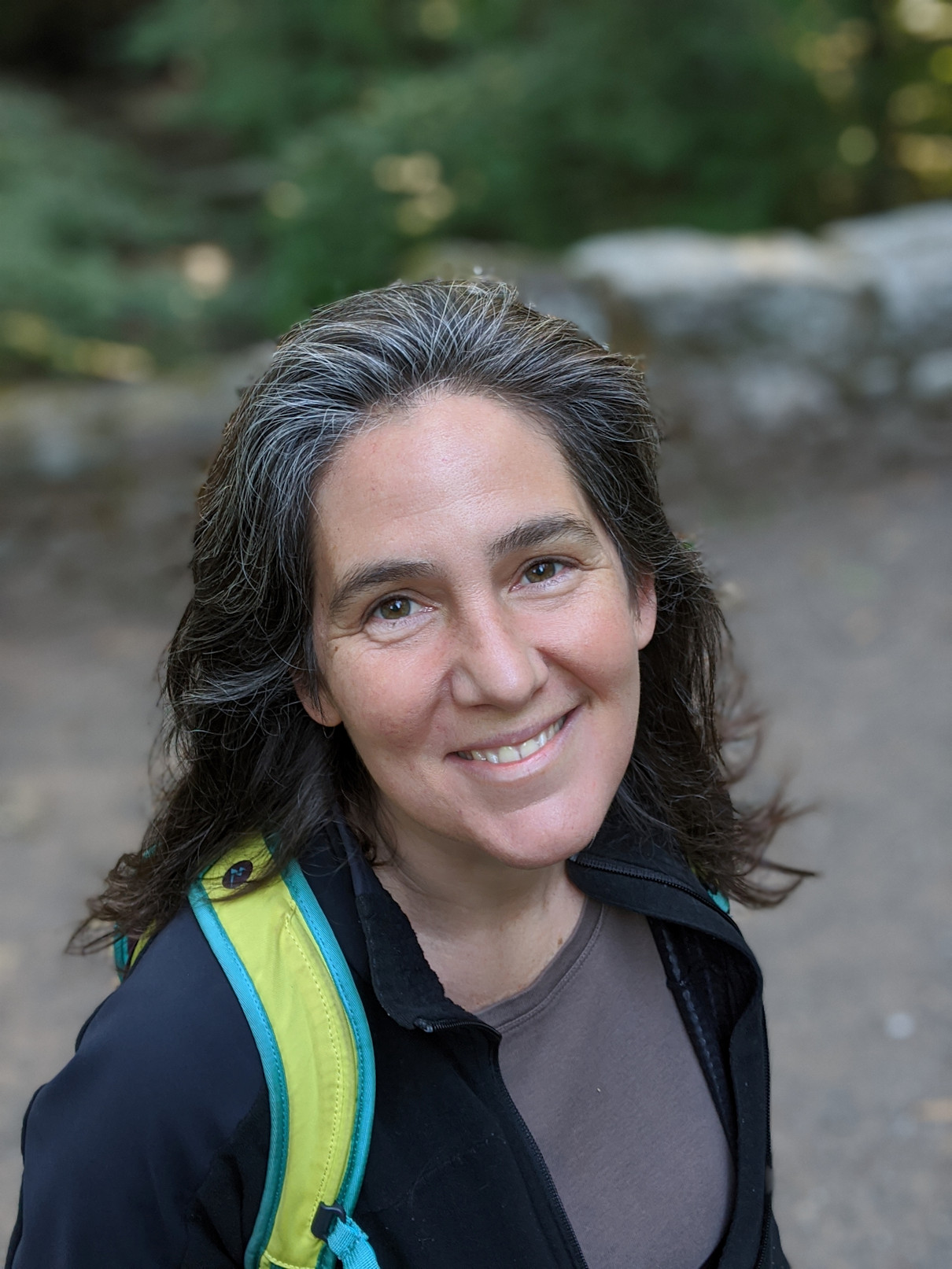 Christine smiling in the woods.